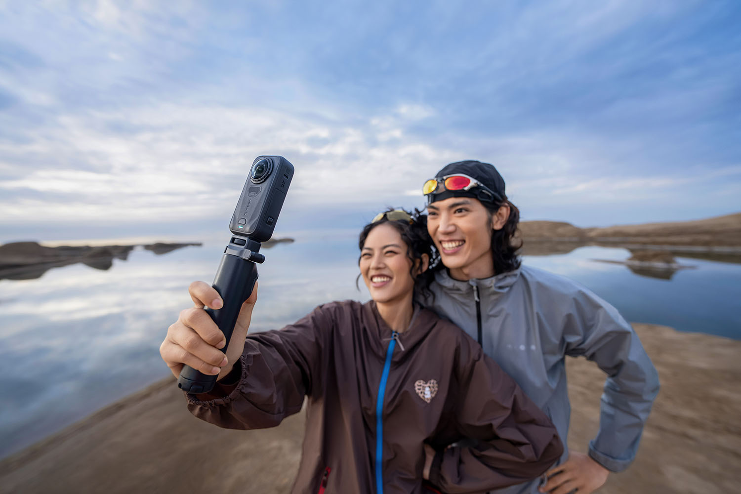 Two friends filming themselves with the X6 at dusk by the water