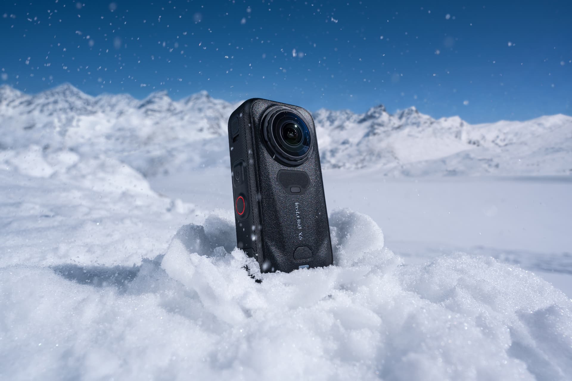 Insta360 X6 standing in fresh snow with mountains behind