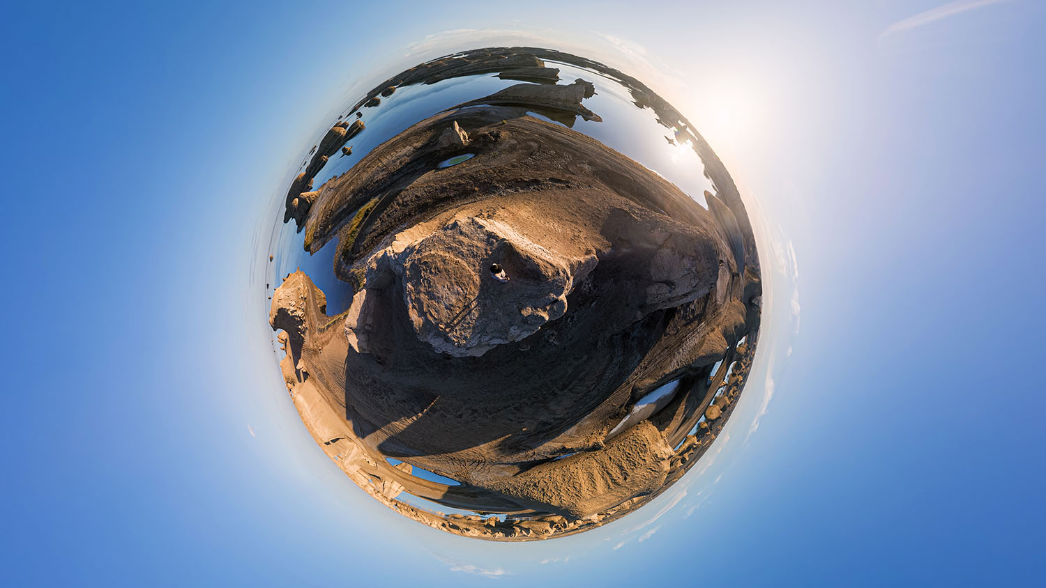 Tiny planet 360 reframe of a desert coastline