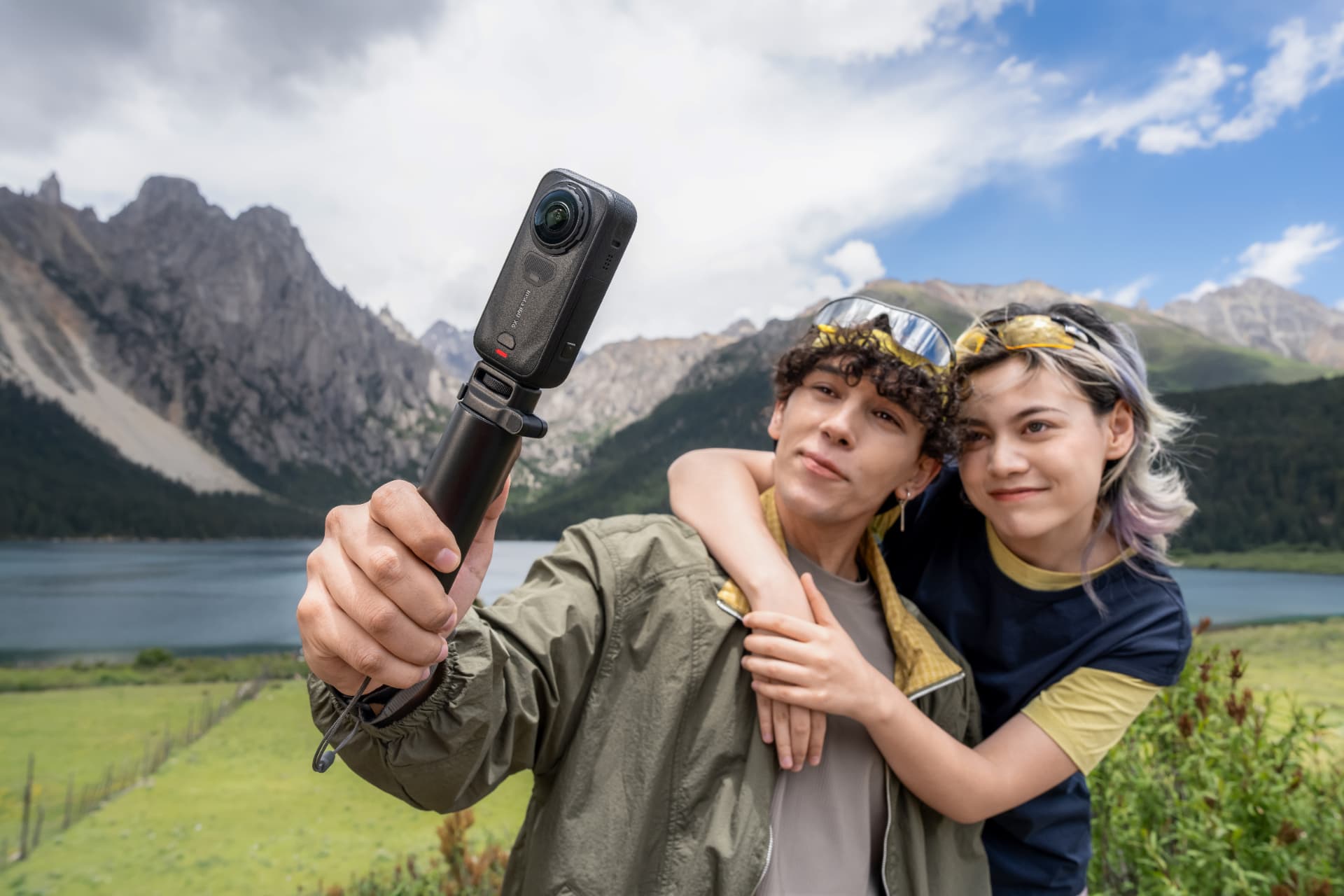 Person holding the Insta360 X6 on a short stick in the mountains